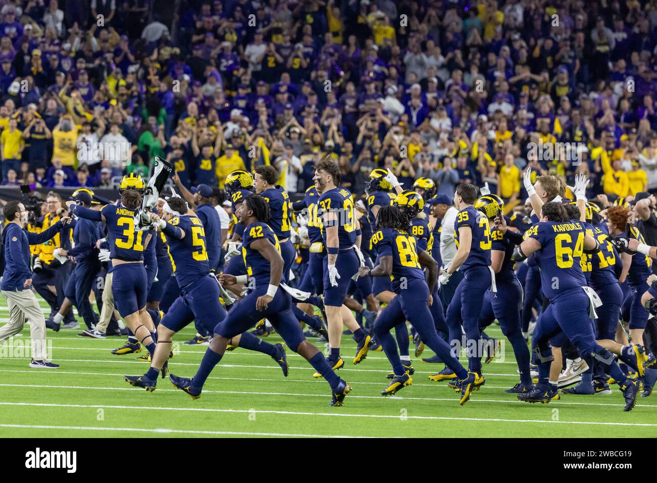 The Michigan Wolverines storm the field in victory over the Washington Huskies during the 2024 College Football Playoff National Championship game, Tu Stock Photo