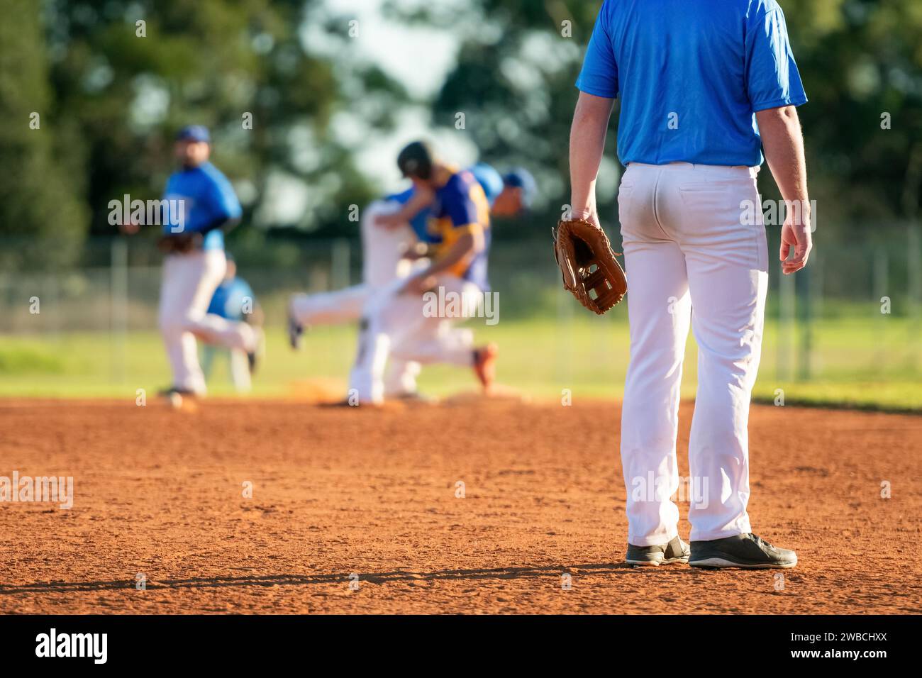 Baseball game, infielder on the third base is watching the close play on the first base during the baseball game Stock Photo