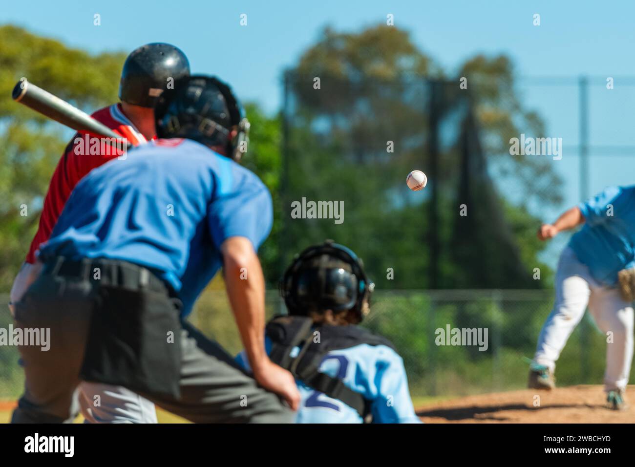 Men playing baseball game. Batter getting ready to hit a pitch during