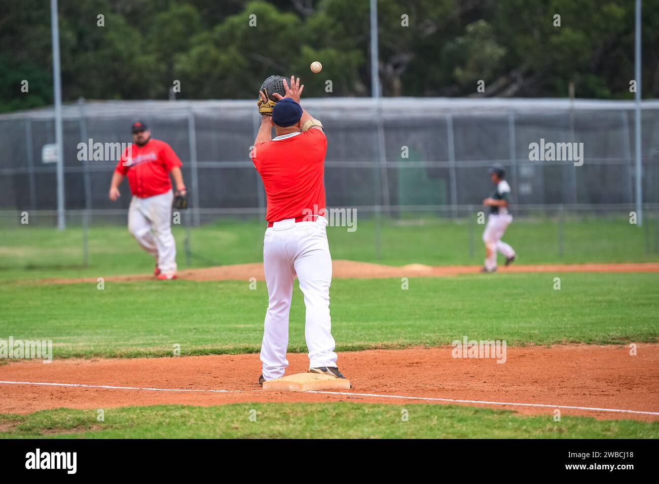 Baseball game, first baseman catching the ball thrown from the infielder during the baseball game. Stock Photo