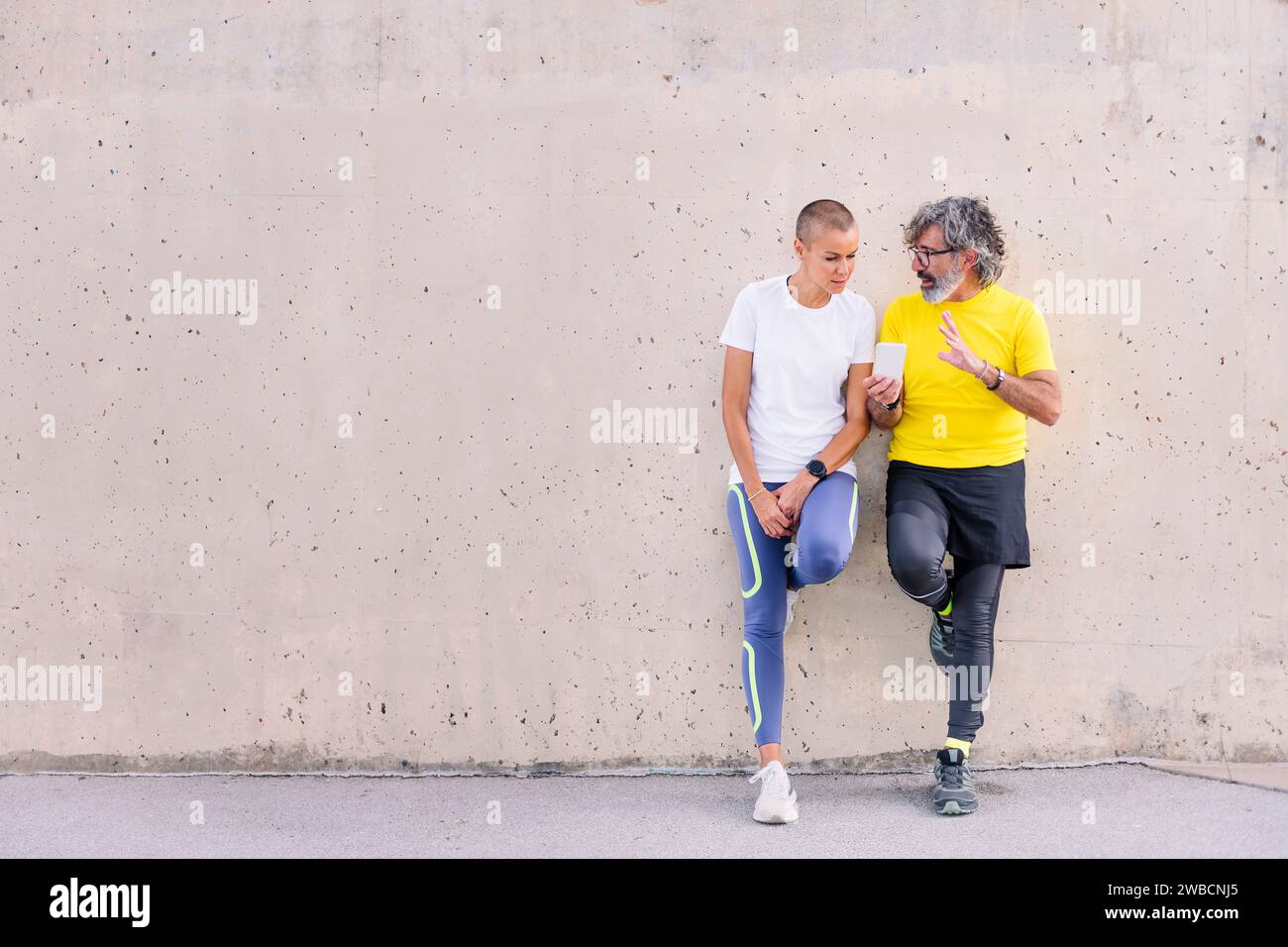 senior man and young woman talking and using phone Stock Photo