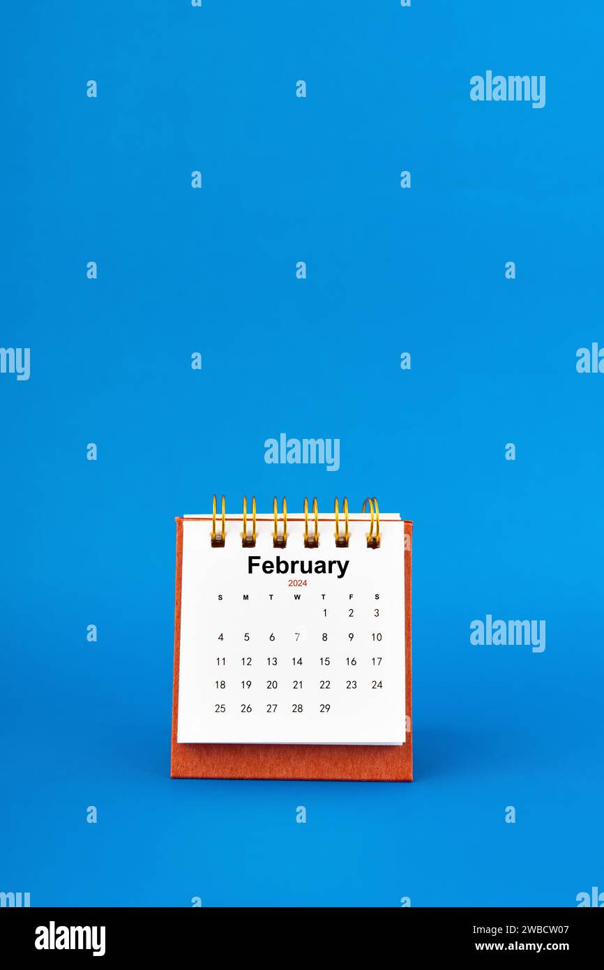 February 2024 white desk calendar on blue color background Stock Photo ...