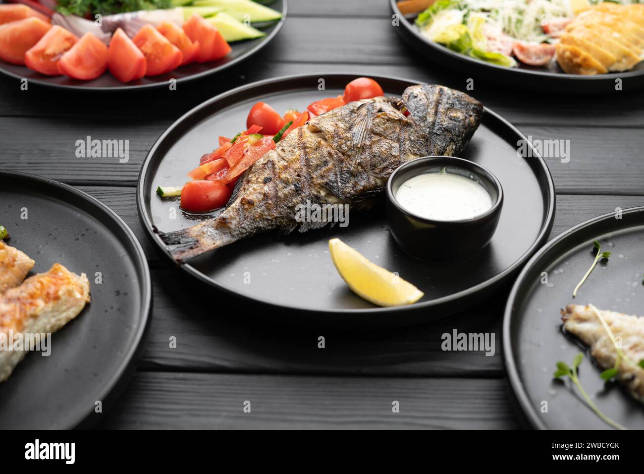 grilled-dorado-fish-served-on-a-black-plate-in-a-restaurant-grill-menu