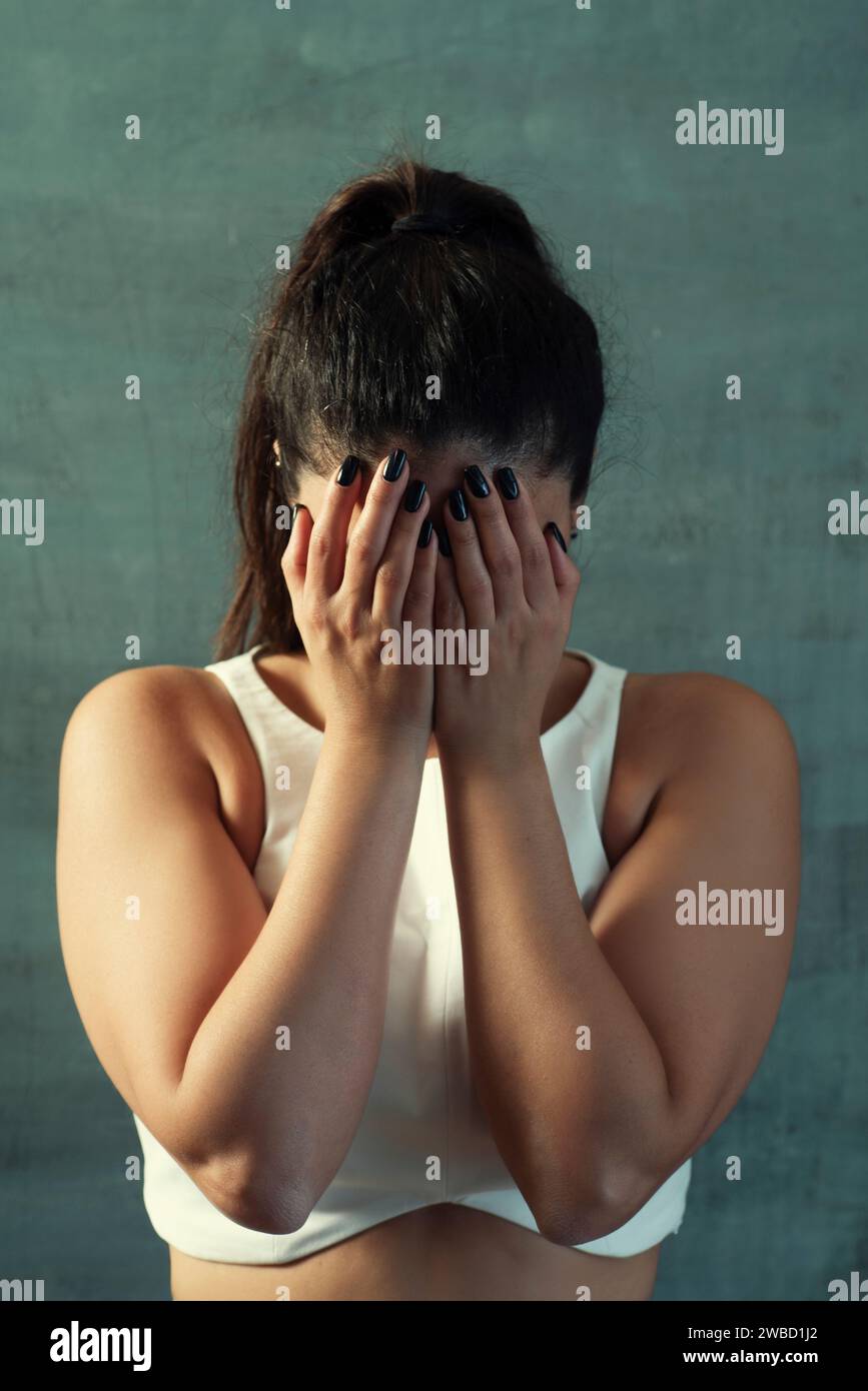 Stressed woman hiding face with hands crying Stock Photo