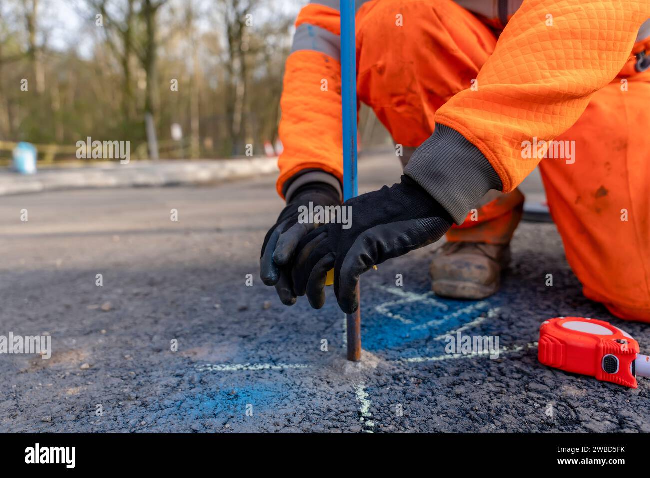 Builder marking future finish road levels on a road setting out steel