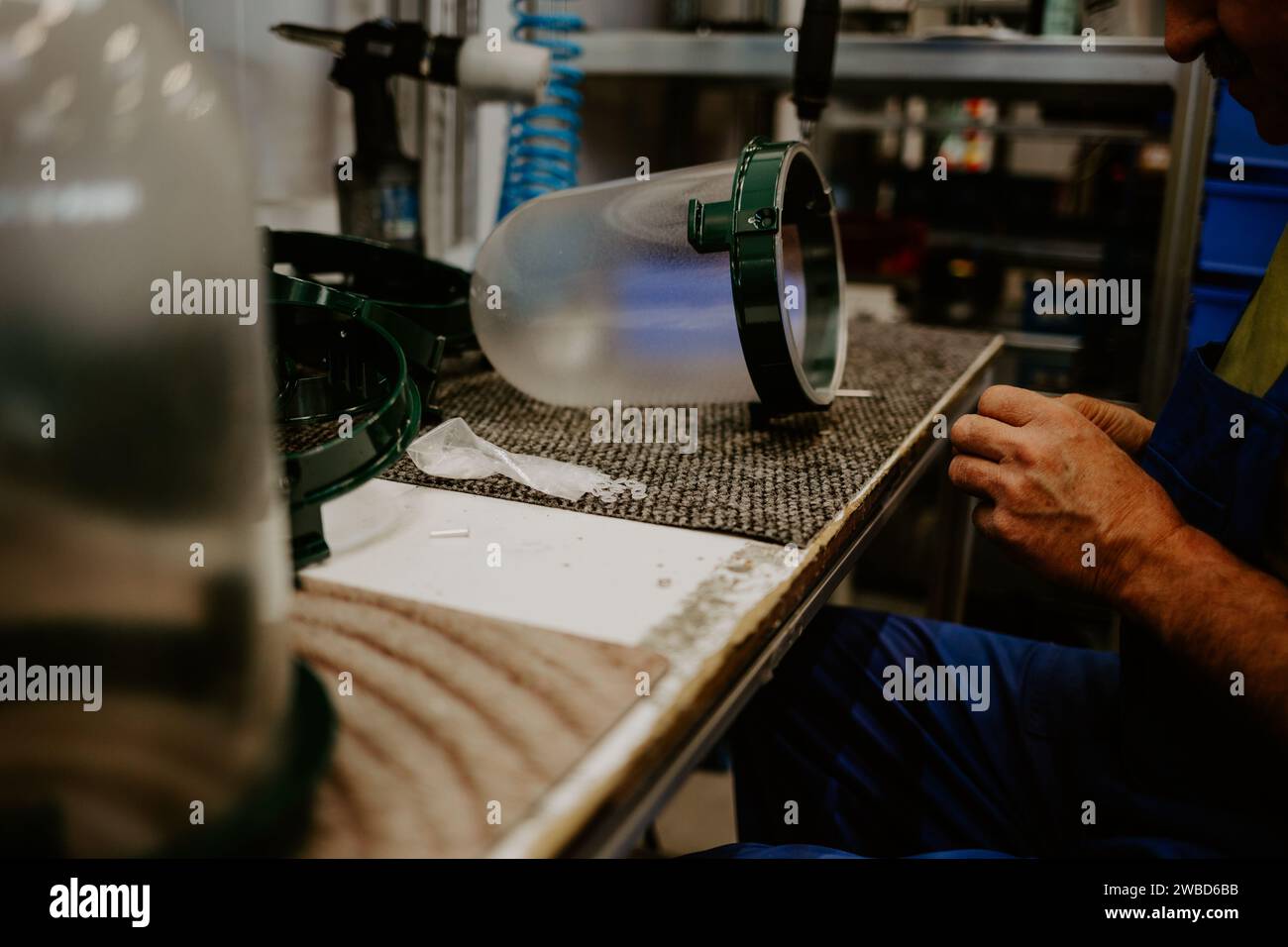 Seamstress or worker in Asian textile factory sewing with industrial sewing machine. Stock Photo