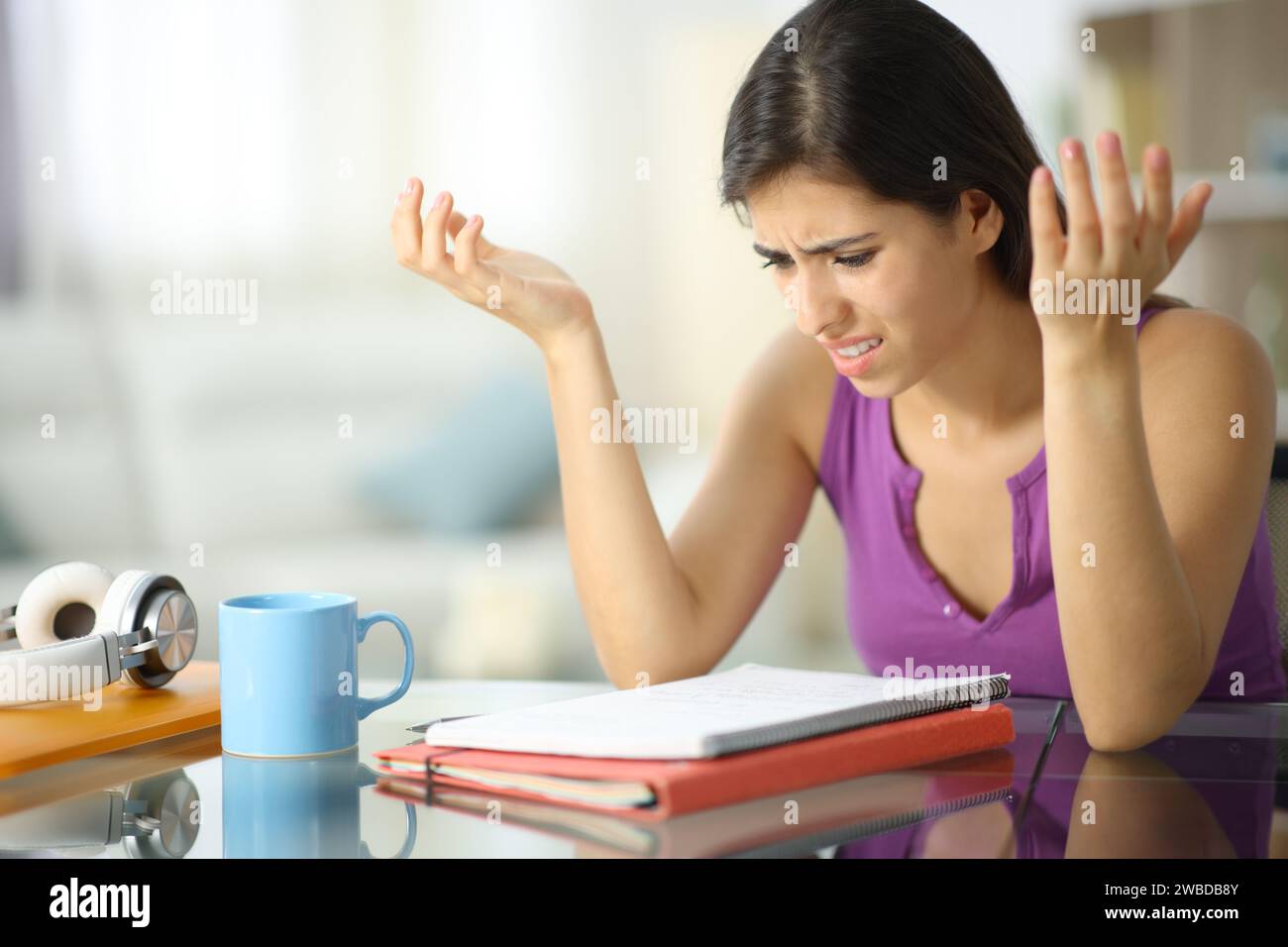 Frustrated student complaining checking notes at home Stock Photo