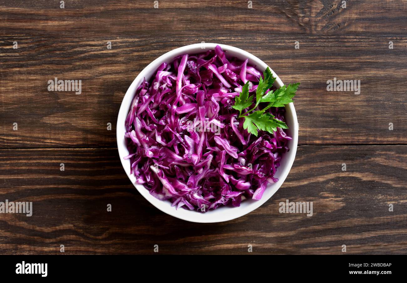Red cabbage in bowl over wooden background. Top view, flat lay Stock Photo
