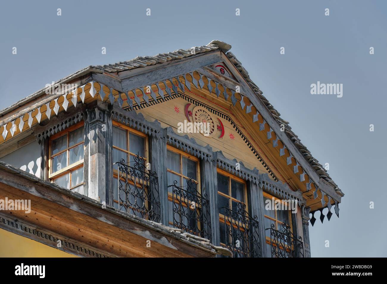 224 Yellow facade of Ottoman-style house with iron-barred windows and profuse wood decoration, old town-Palorto district. Gjirokaster-Albania. Stock Photo