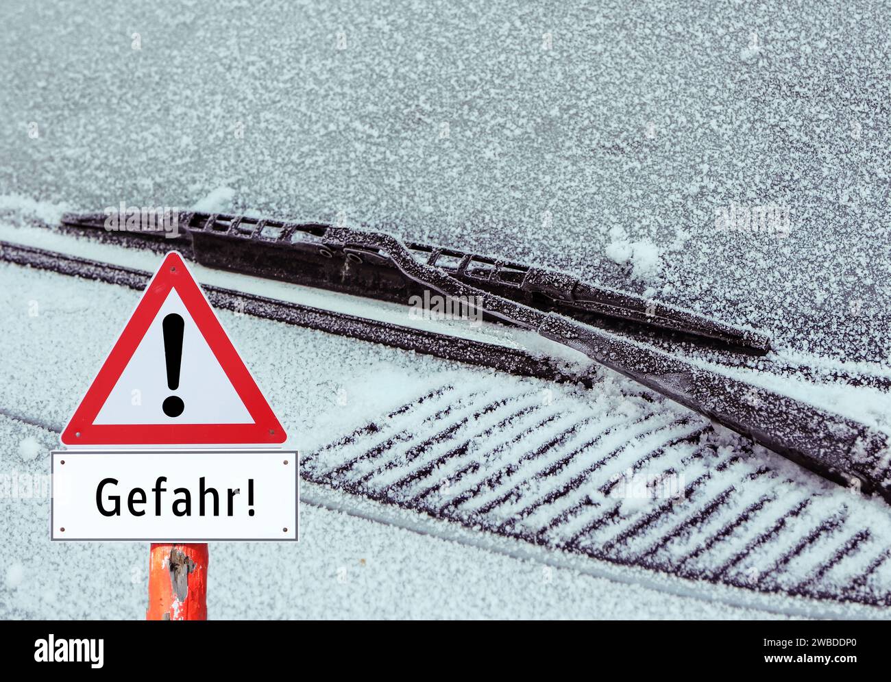 Red warning sign with the word danger in German frozen windshield Stock Photo