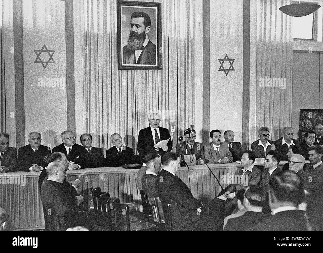 DAVID BEN-GURION as First Prime Minister of Israel announcing the Declaration of the State of Israel in Tel Aviv, 14 May 1948. Behind him is a portrait of Theodor Herzl Stock Photo