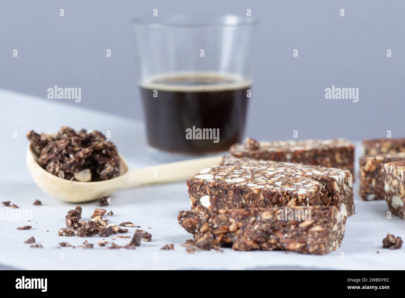 Dresden, Germany. 06th Jan, 2024. Cashew date bars lie on baking paper in front of a glass of coffee. Credit: Sebastian Kahnert/dpa/Alamy Live News Stock Photo