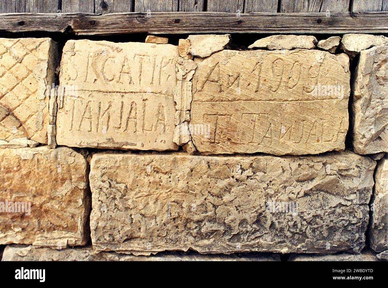 Colacu, Vrancea County, Romania, approx. 1990. Carved inscription with the family name Tanjala and the construction year 1909 on the foundation of a local house. Stock Photo
