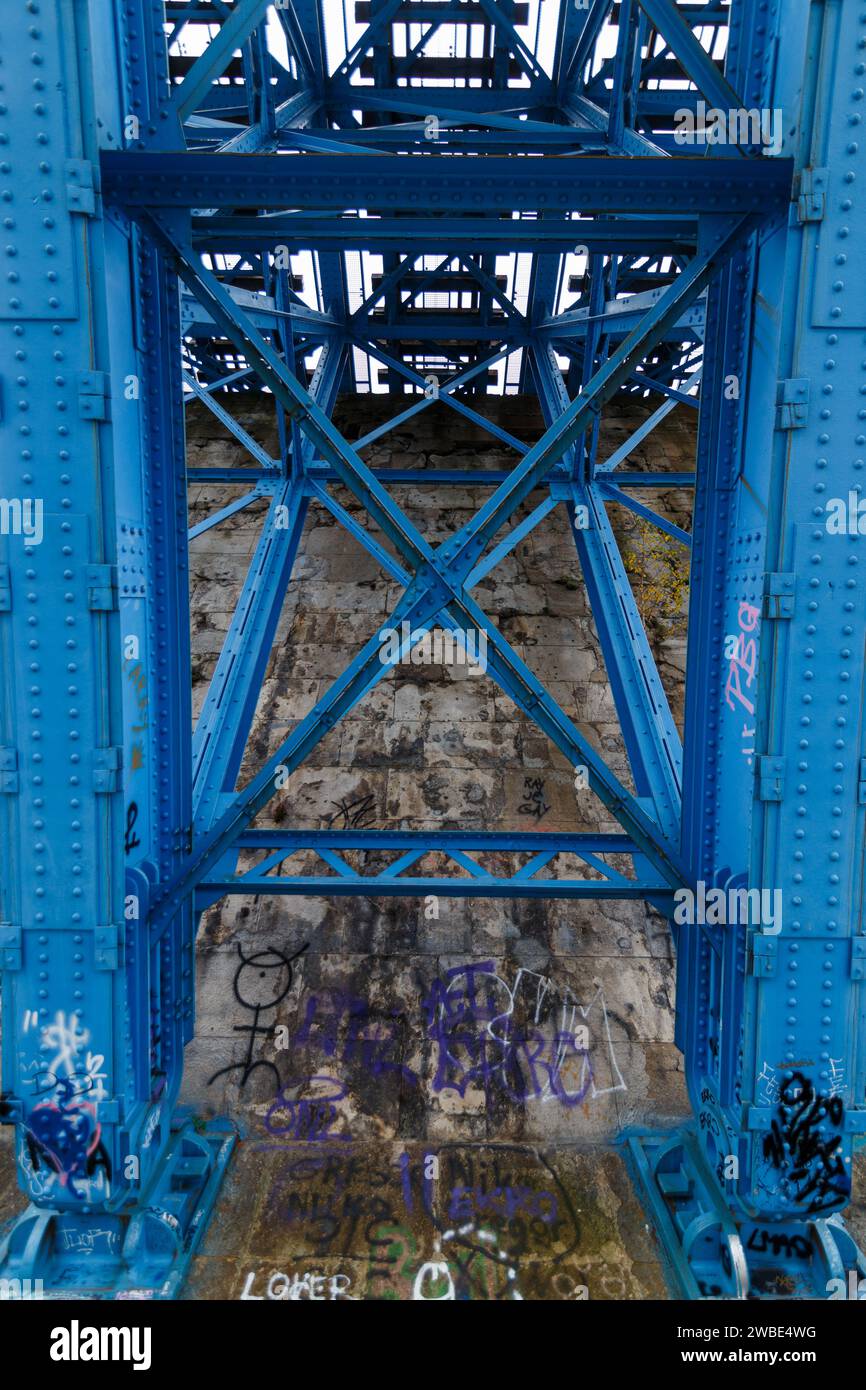 Photo of graffiti artwork on concrete. This is under a train bridge made out of metal Stock Photo