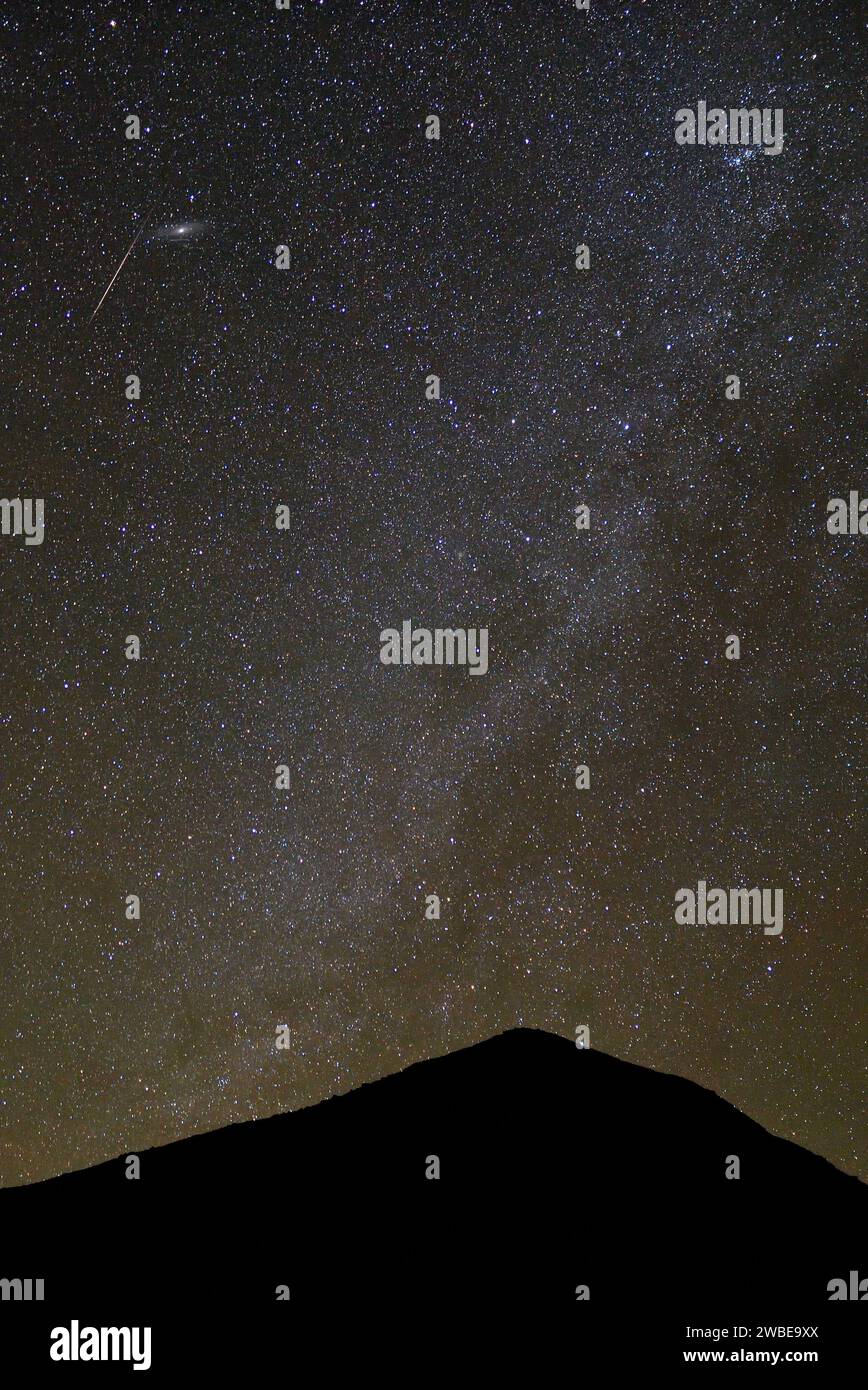 MILKY WAY AND THE SHOOTING STARS DURING THE GEMINID METEOR SHOWER IN THE ALGERIAN DESERT Stock Photo