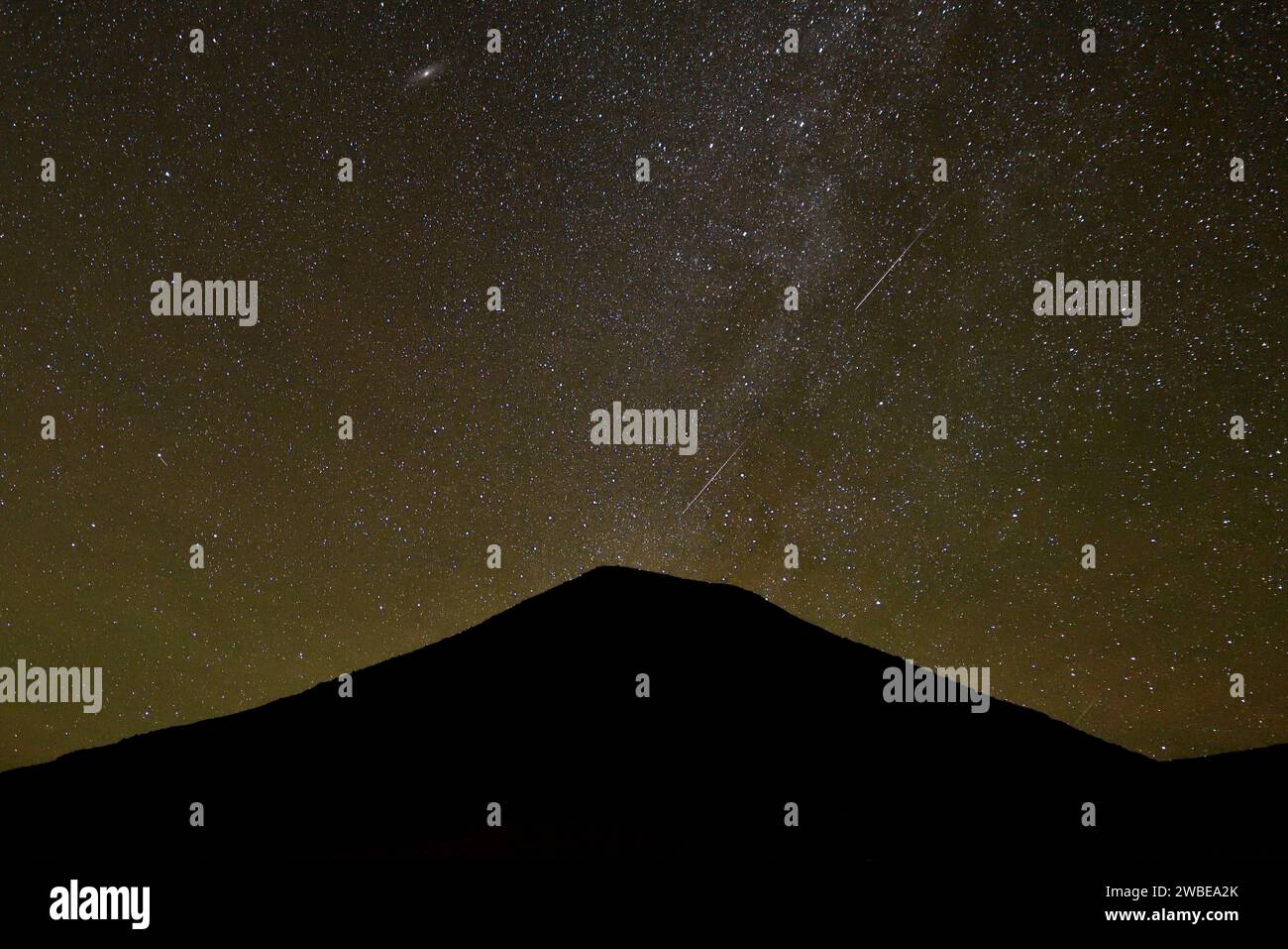 MILKY WAY AND THE SHOOTING STARS DURING THE GEMINID METEOR SHOWER IN THE ALGERIAN DESERT Stock Photo