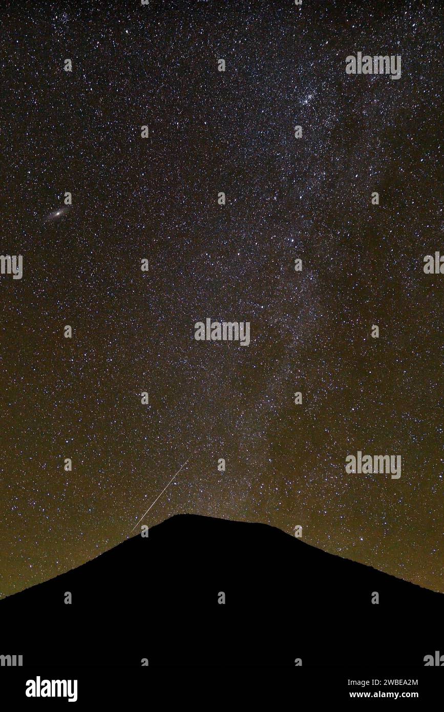 MILKY WAY AND THE SHOOTING STARS DURING THE GEMINID METEOR SHOWER IN THE ALGERIAN DESERT Stock Photo