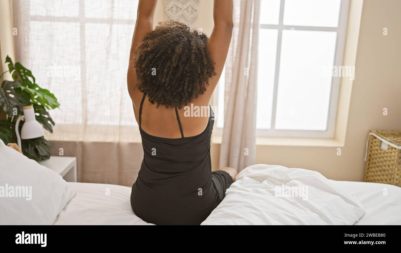 African american woman with braids stretching in bedroom Stock Photo ...