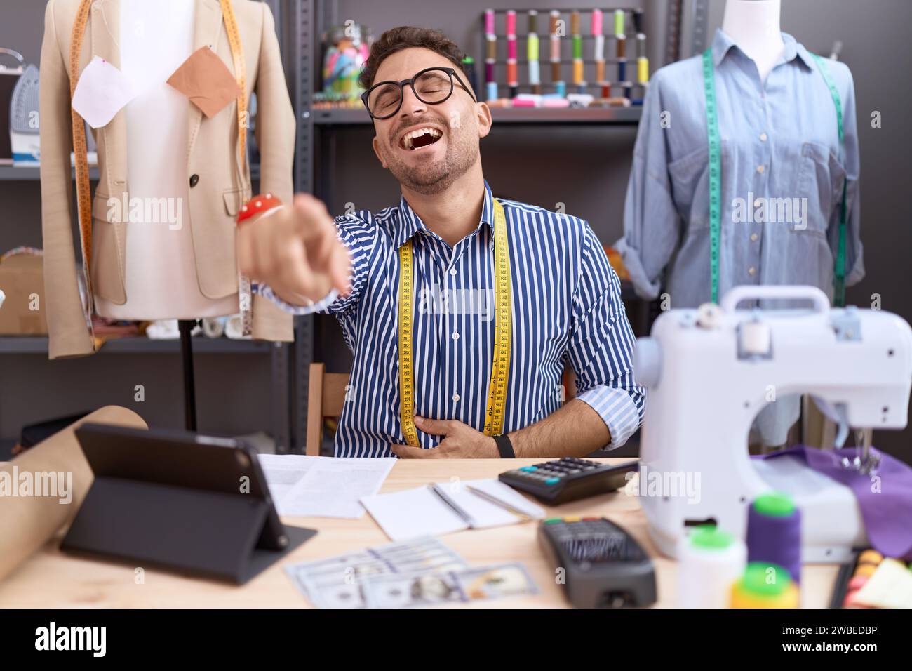 Hispanic man with beard dressmaker designer working at atelier laughing ...