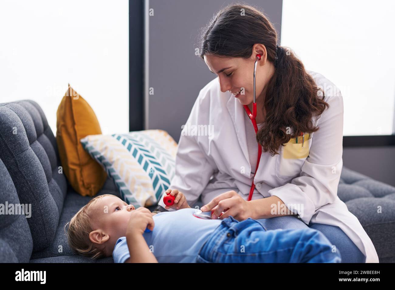 Mother and son doctor examining child at home Stock Photo - Alamy