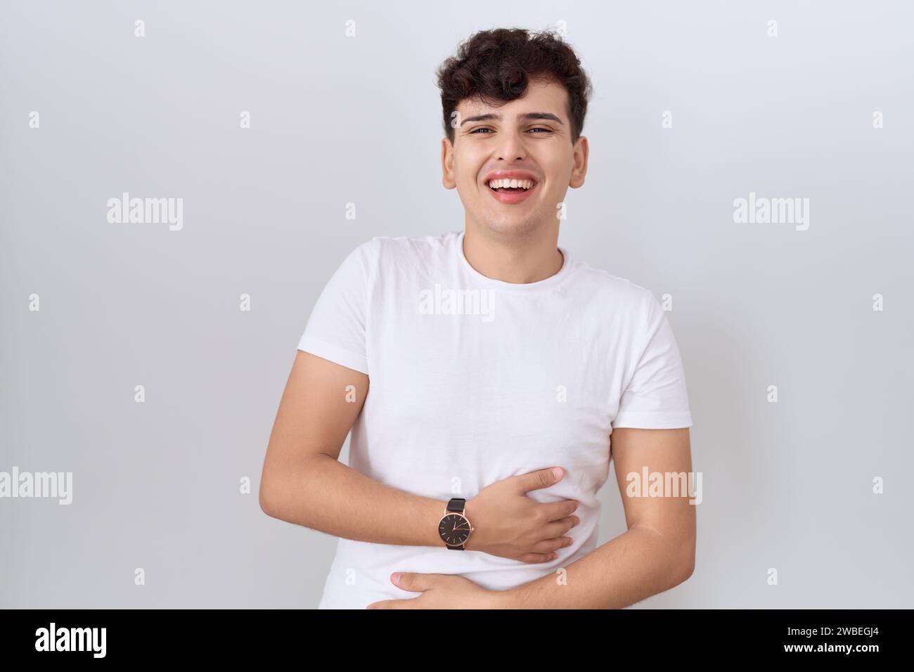Young non binary man wearing casual white t shirt smiling and laughing ...