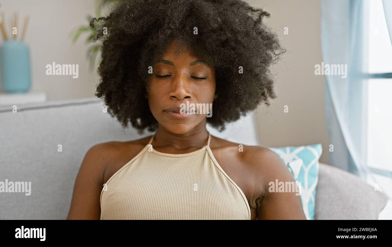 African american woman sitting on sofa with serious face and closed ...