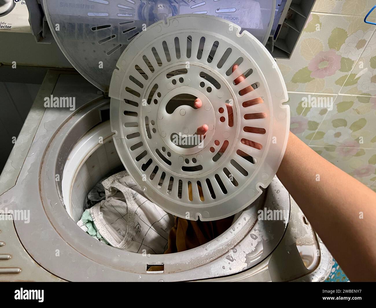 Washing clothes, spinning clothes in the dry cleaning tank in the old washing machine Stock