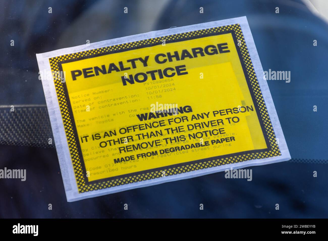 Parking fine, Penalty Charge Notice on car windscreen issued for parking on a road with double yellow lines near a hospital Stock Photo