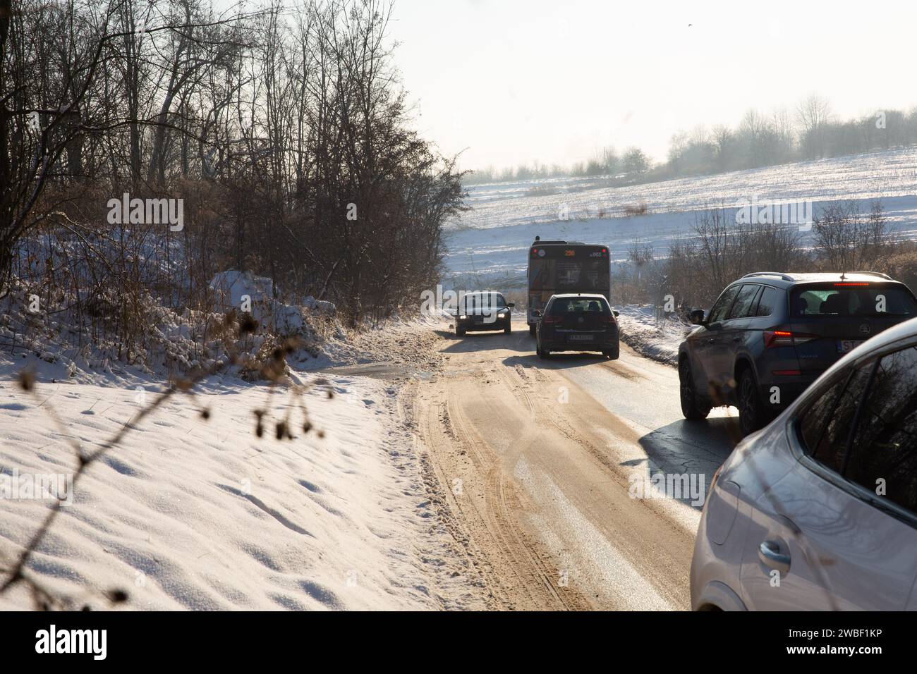 Krakow, Poland, 10 January 2024. Cars drive on snow and ice in the suburbs of Krakow as the temperatures dropped and  snow fell in southern Poland. The roads in the suburbs are neglected. Stock Photo