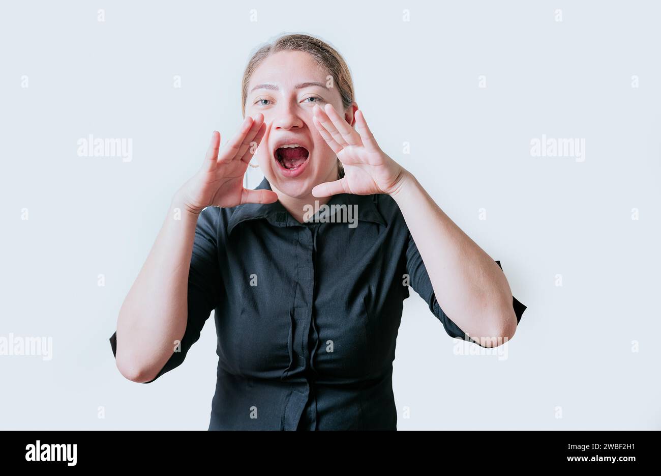 Female teenager announcing something to the camera. Young girl screaming and announcing at the camera Stock Photo
