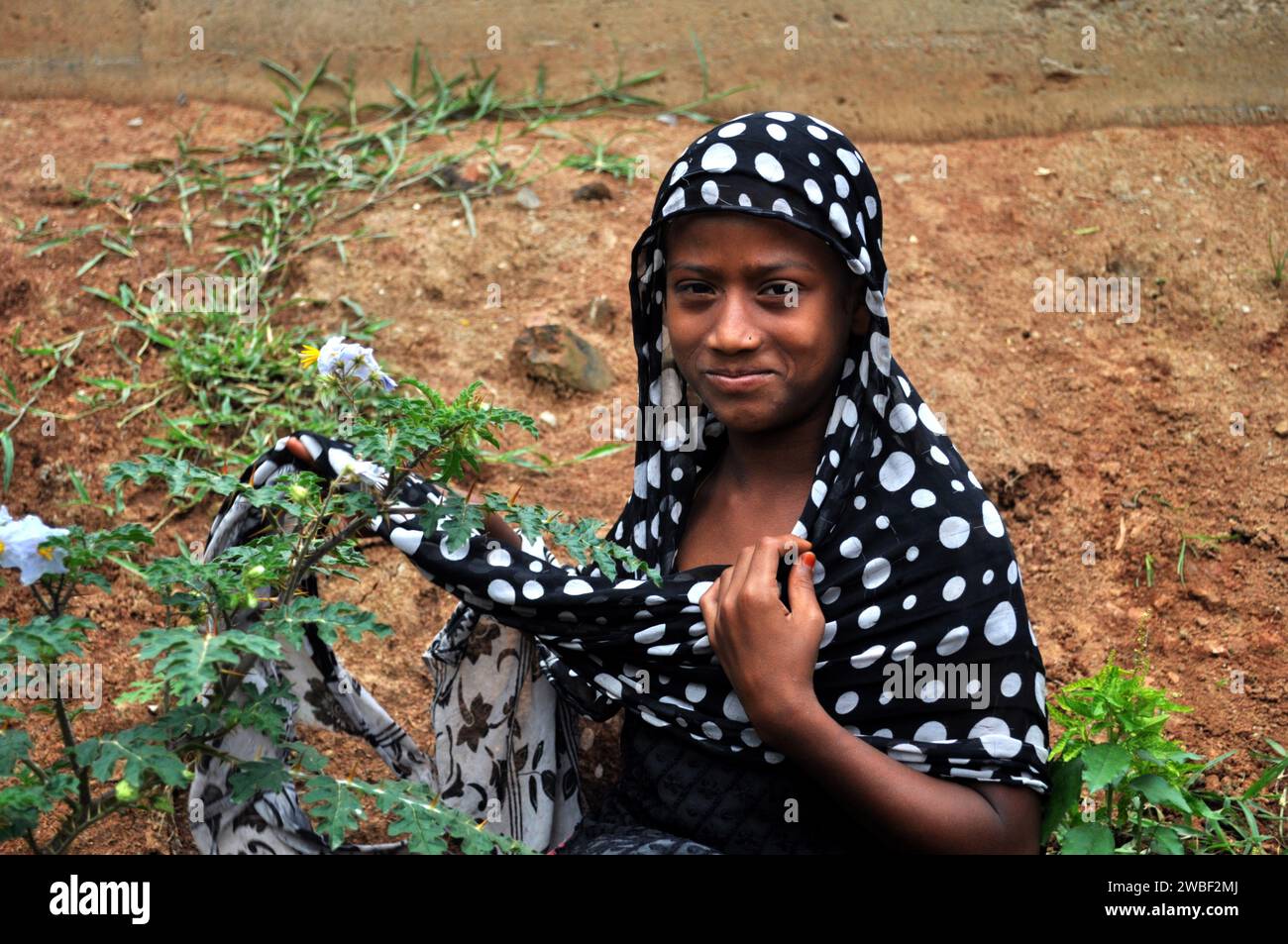 Portrait of a woman plantng trees in the slums of Rayer bazar ...