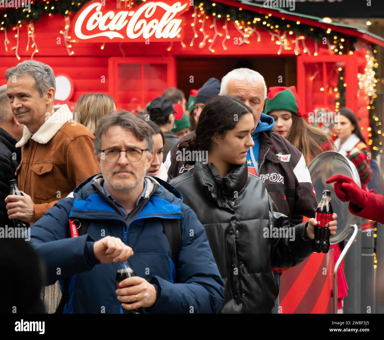 Belgrade, Serbia - January 5, 2024: Coca Cola promotion campaign on city street during Christmas holiday market, giving away free drinks to people Stock Photo