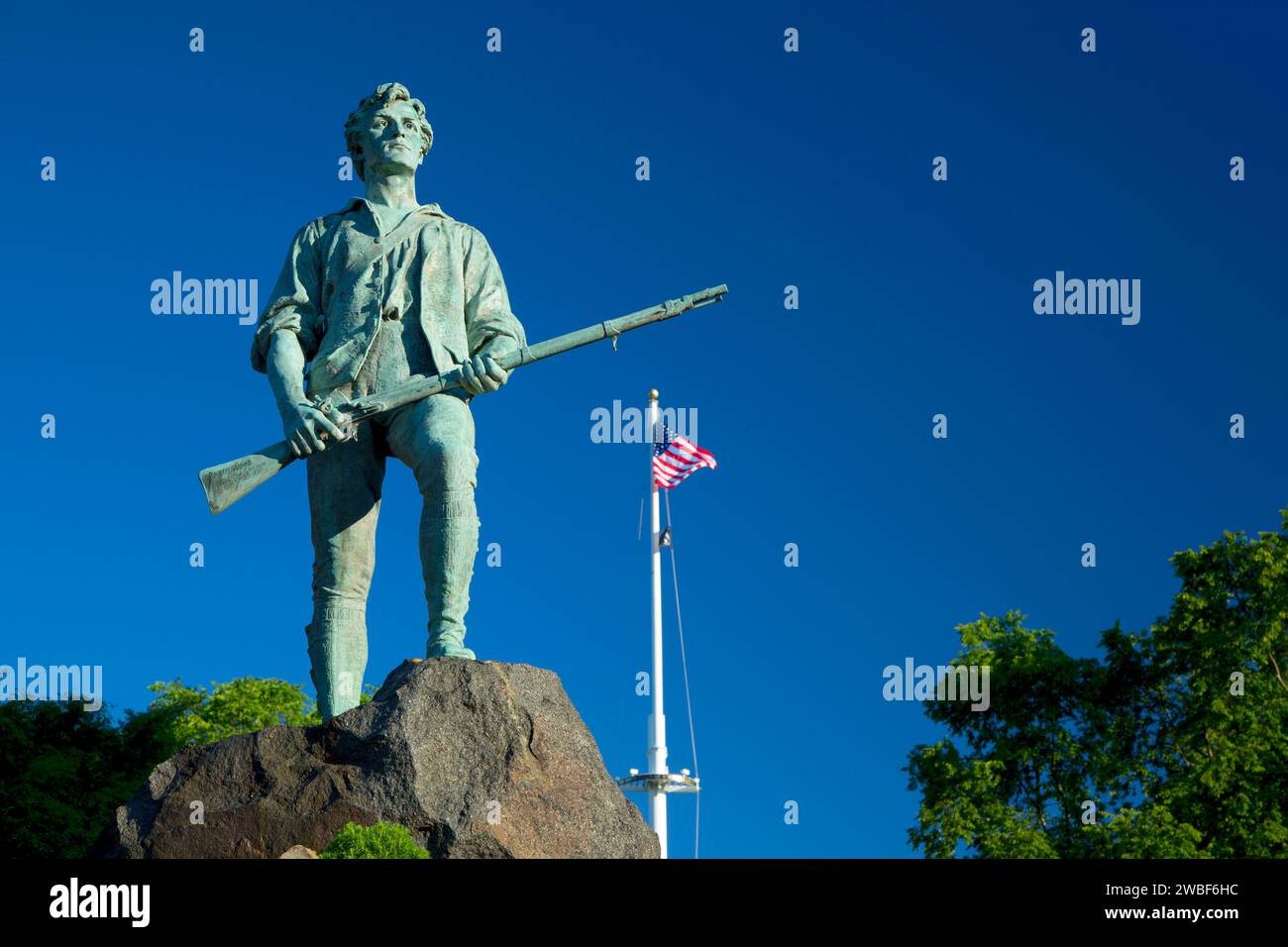 Captain Parker statue on Battle Green with American flag, Lexington Green, Lexington,  Massachusetts Stock Photo