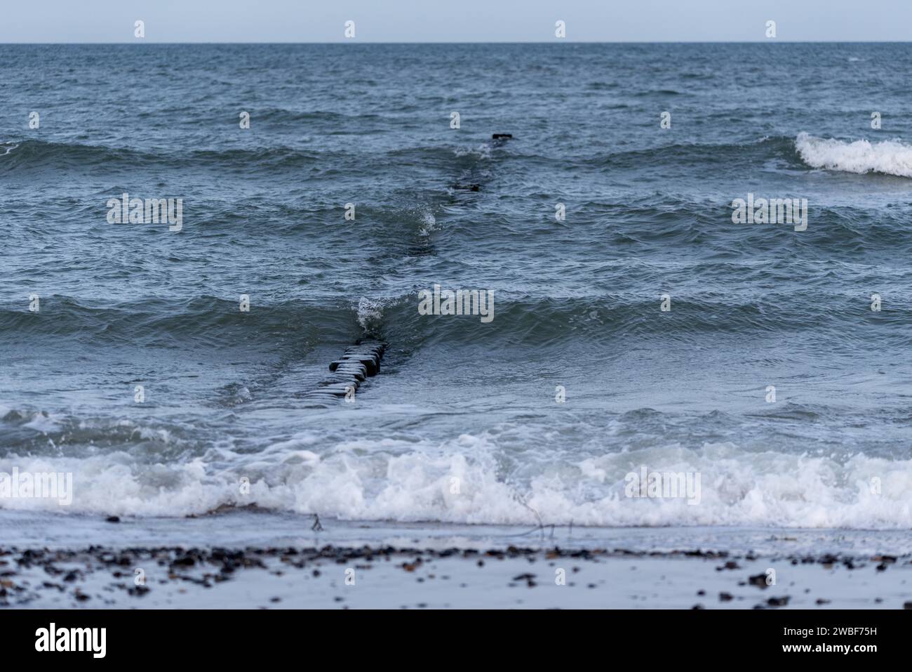 View of foam waves gently lapping against a sandy beach, breakwater, Baltic Sea, Zingst, Mecklenburg-Western Pomerania, Germany Stock Photo