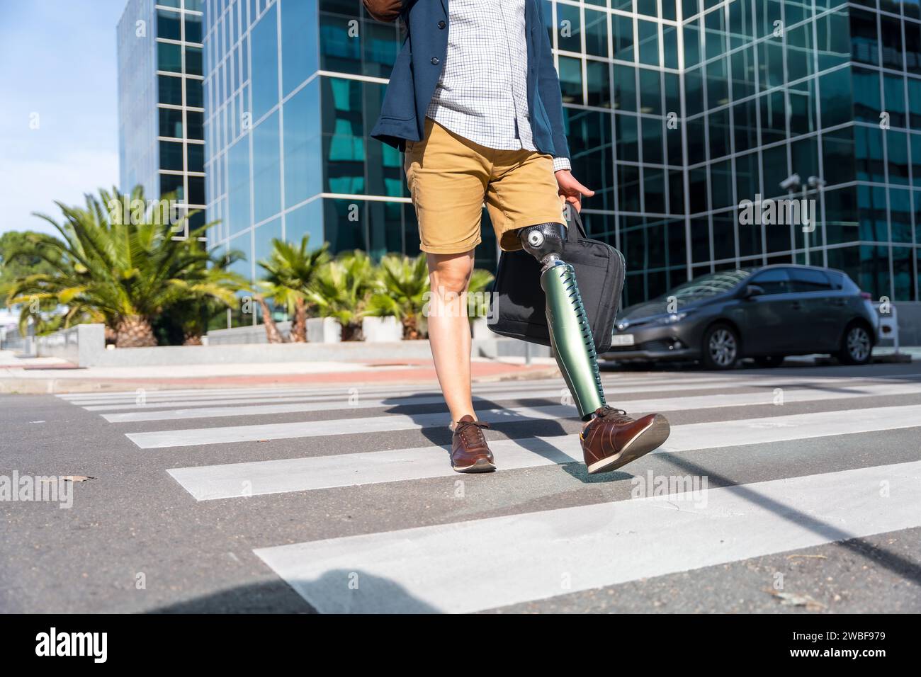 Unrecognizable businessman with prosthetic leg walking in the city Stock Photo