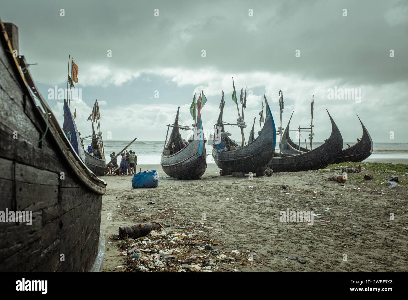 Fishing boats on the beach during a monsoon shower, Cox's Bazar, Bangladesh Stock Photo