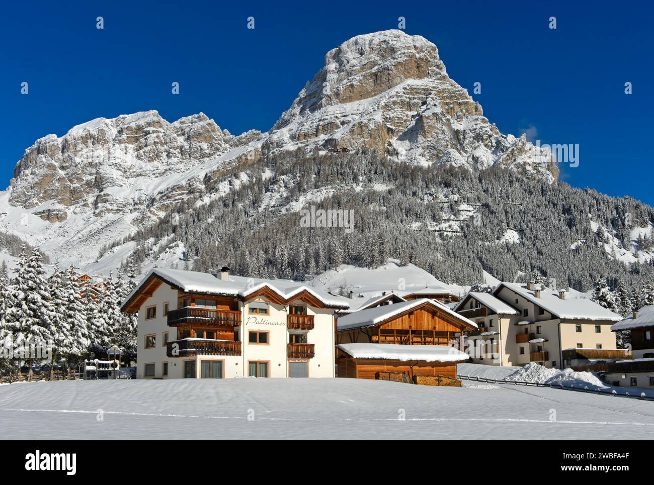 The snow-covered hamlet of Colfosco, Colfosco, at the foot of the Sassongher peak, Colfosco, Corvara, Alta Badia ski area, Dolomites, South Tyrol Stock Photo
