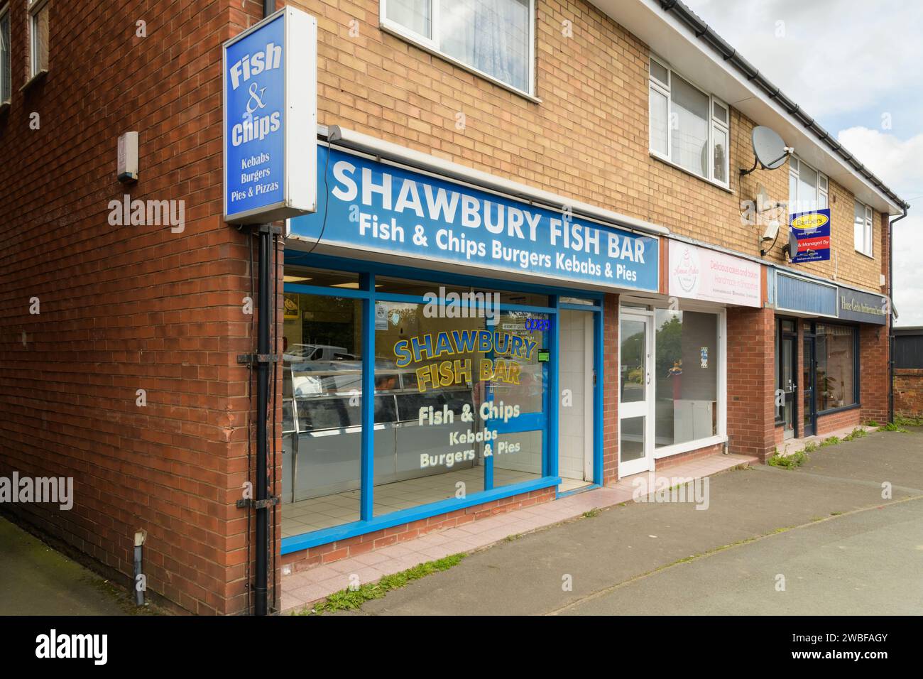 Shawbury, UK - May 5, 2023; Row of small english businesses including traditional fish and chip shop Stock Photo