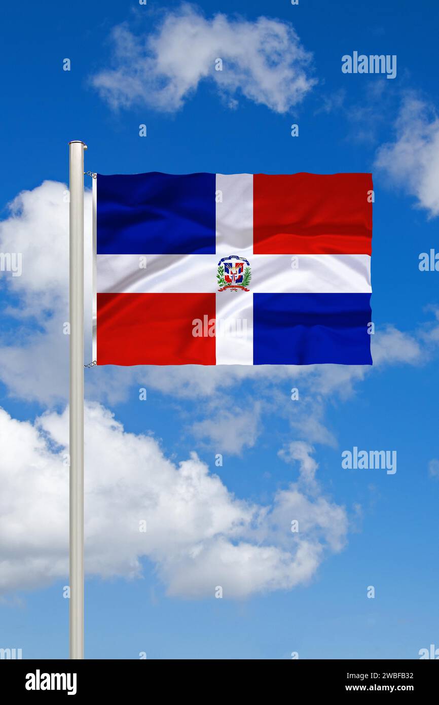 National flag of the Dominican Republic, island of Hispaniola, in front of cumulus clouds and blue sky, studio Stock Photo