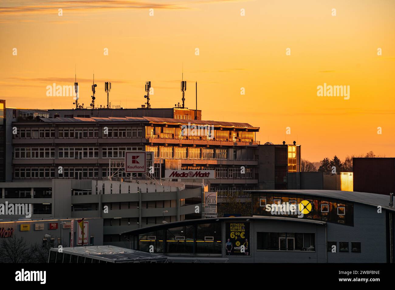 Building with antennas on the roof against a sky flooded with warm light at sunset, Wilferdinger Hoehe, Pforzheim, Germany Stock Photo