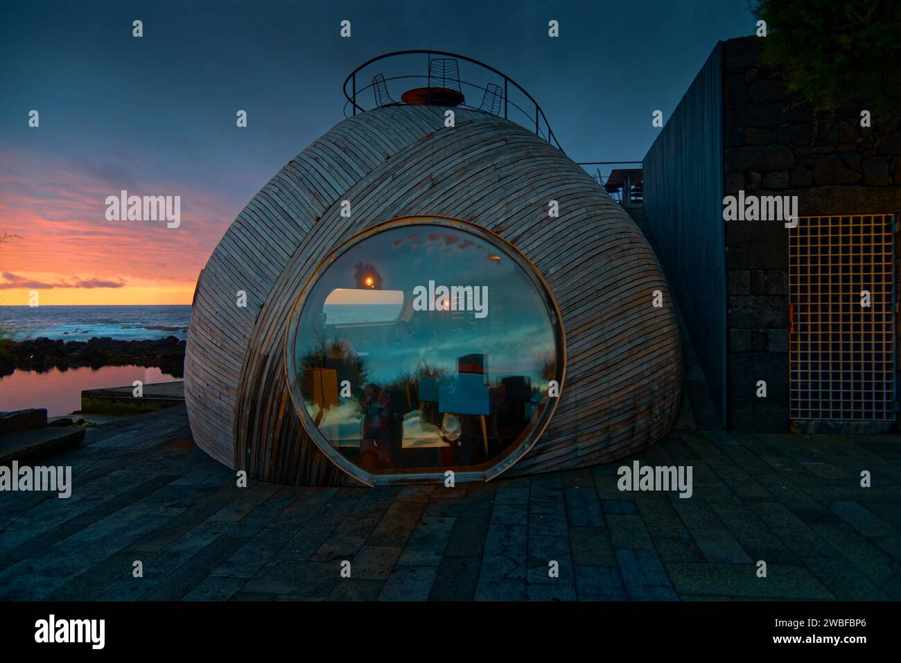 Spherical wooden building of the Cella Bar with modern design at sunset, reflections on the glass window, Madalena, Pico, Azores, Portugal Stock Photo