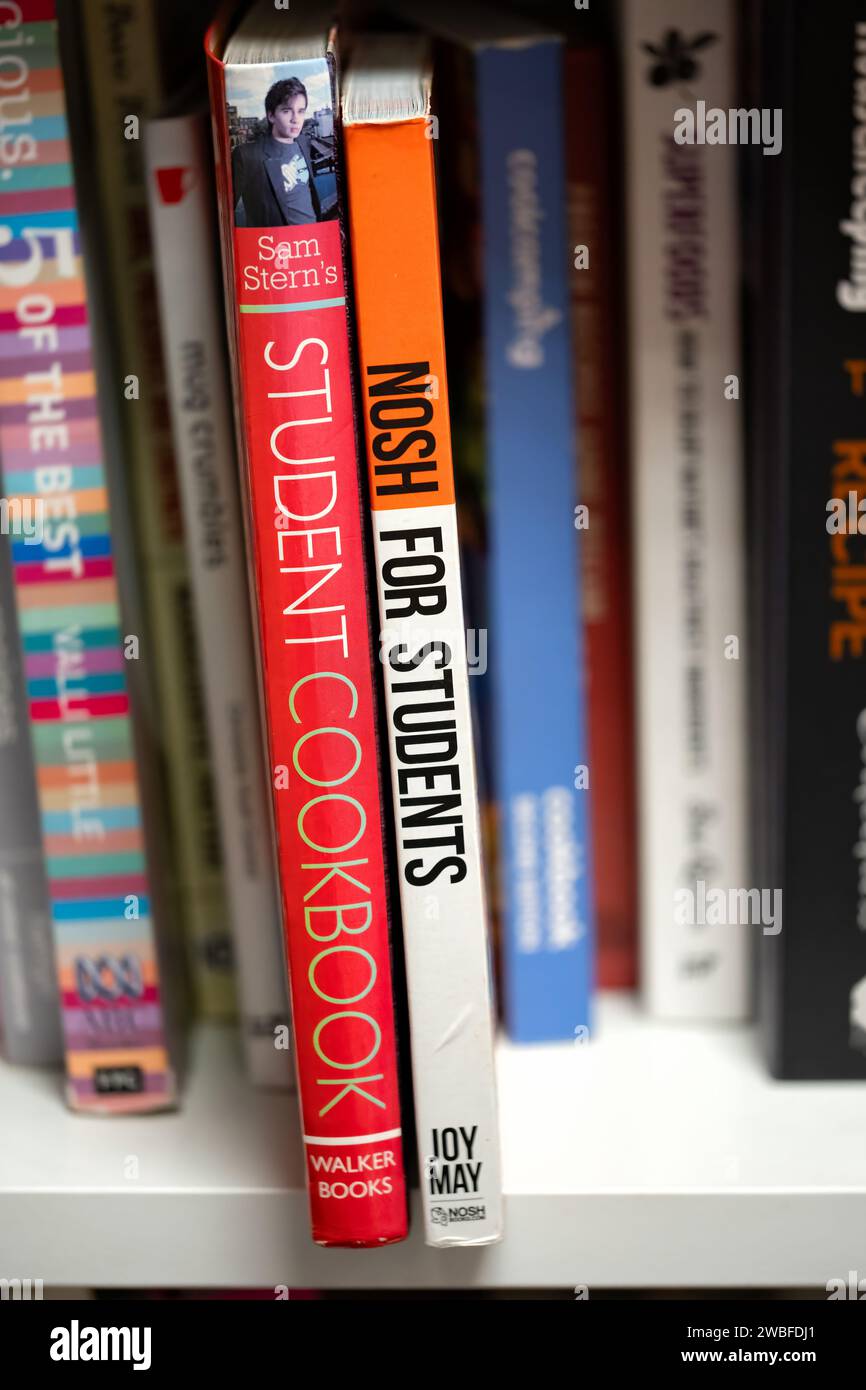 Two cookery books written for students probably living away from home for the first time. The books are on a bookshelf in a UK charity shop Stock Photo