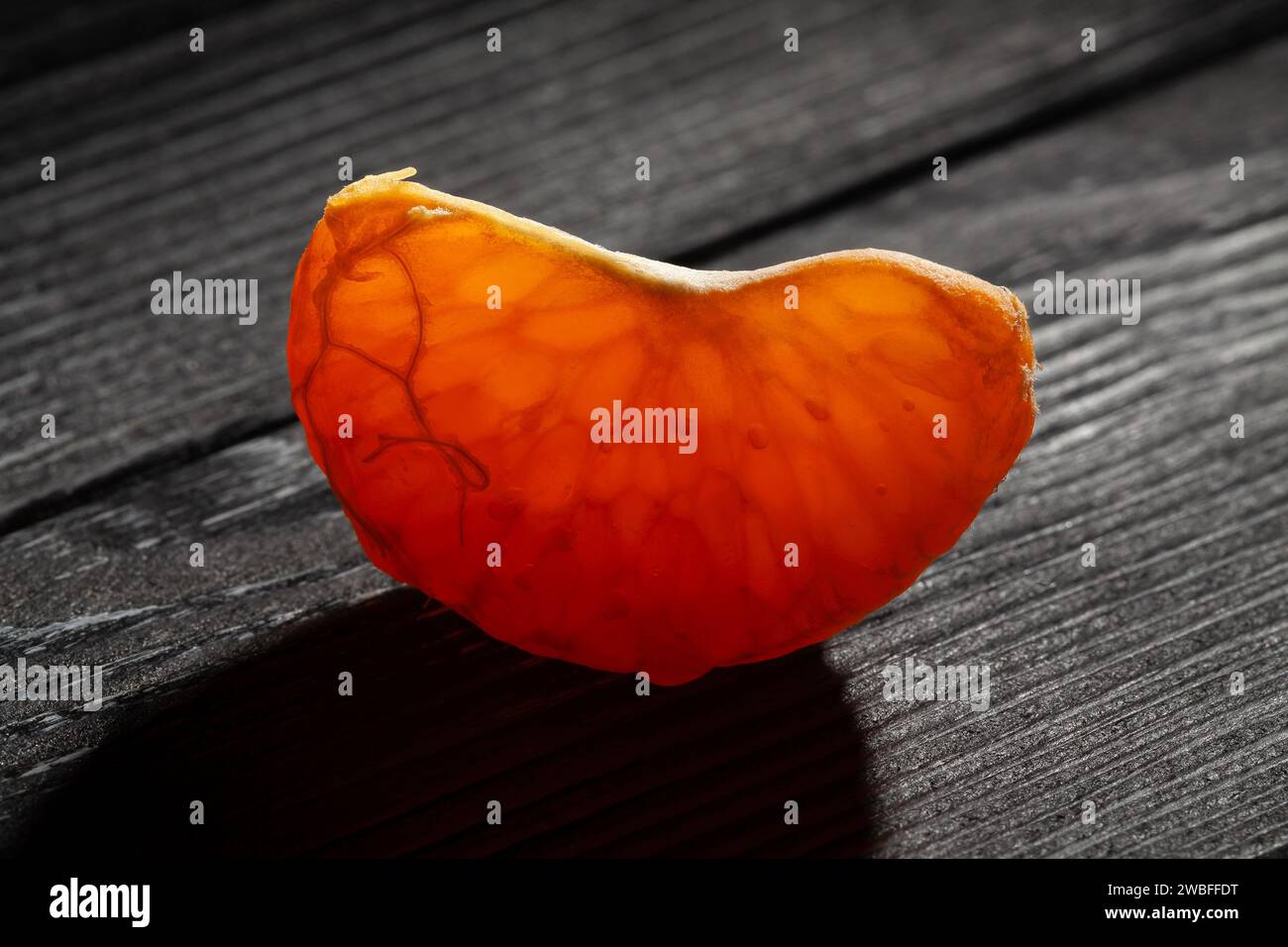 sliced tangerine on black wood background Stock Photo