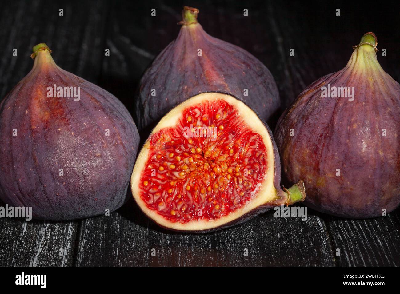 sliced figs on wood background Stock Photo