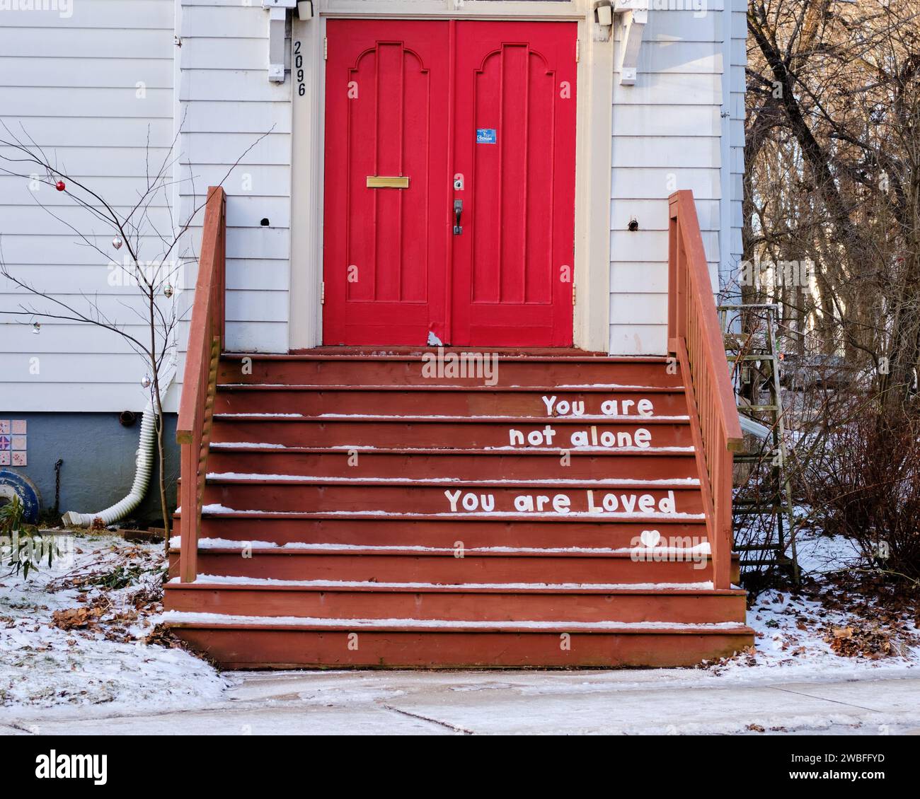 you are not alone, you are loved, sign on steps of a church Stock Photo