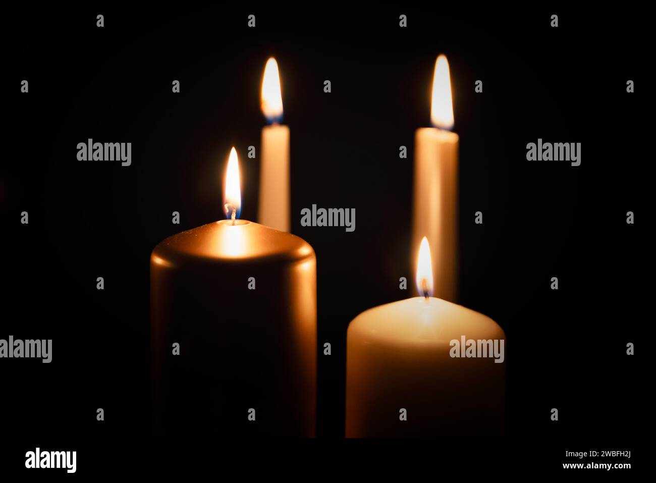 Candles burning in darkness over black background. Commemoration, necrology notice concept Stock