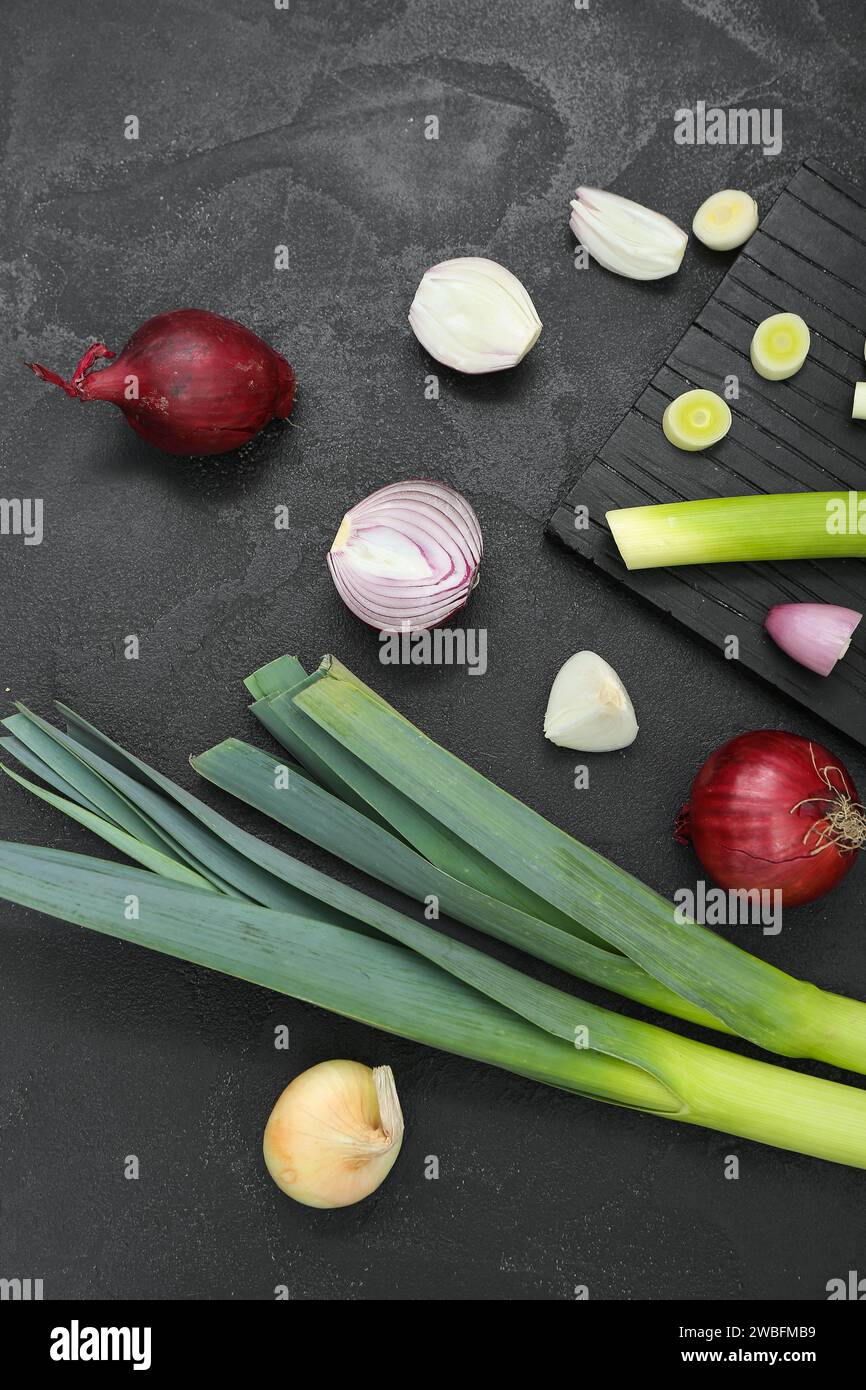 Board with different kinds of onion on grunge black background Stock ...