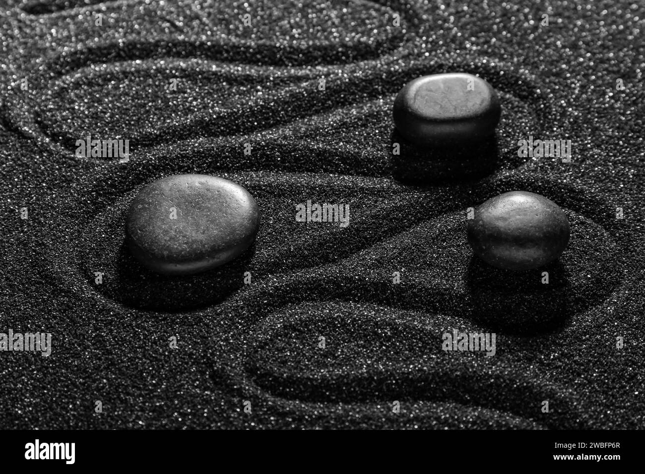 Stones on dark sand with lines in Japanese rock garden. Zen concept Stock Photo