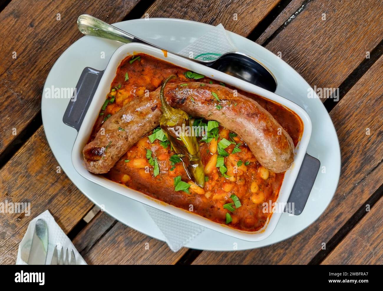 A plate of delicious smoked sausage links, cooked to perfection and ready to be enjoyed, sits on a table Stock Photo
