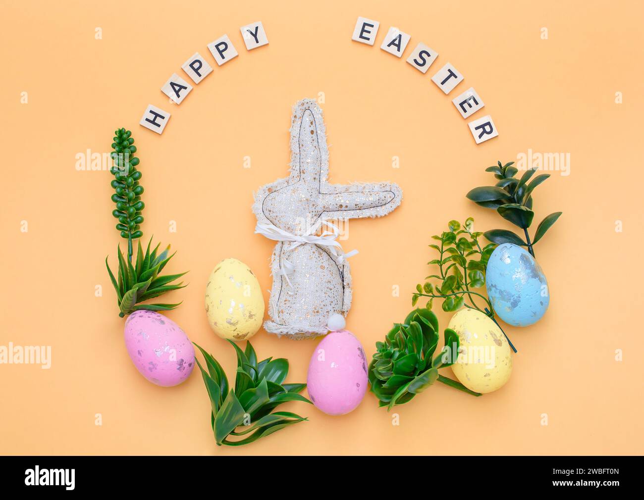 Handmade Easter decor, stylish Easter eggs, textile rabbit willow branches and flowers on light background. Easter wreath shape Stock Photo